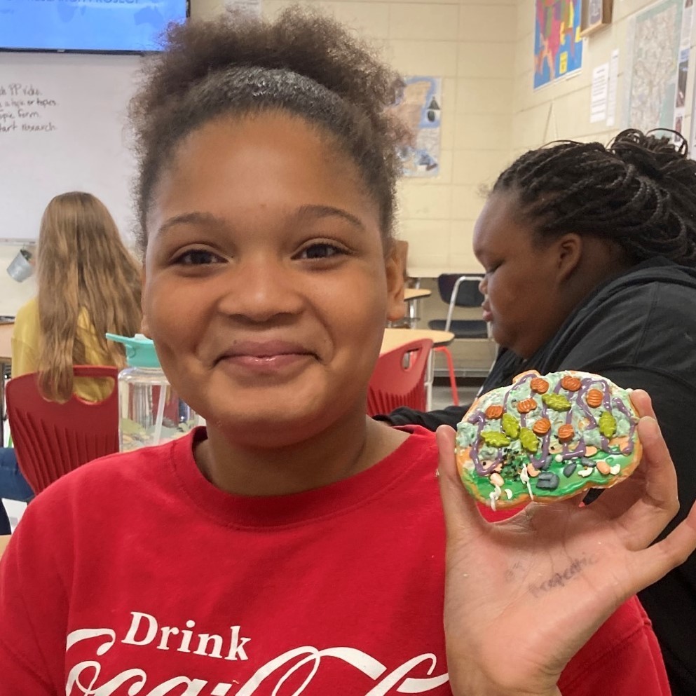 Briley Hardwell holds up her festive pumpkin cookie.