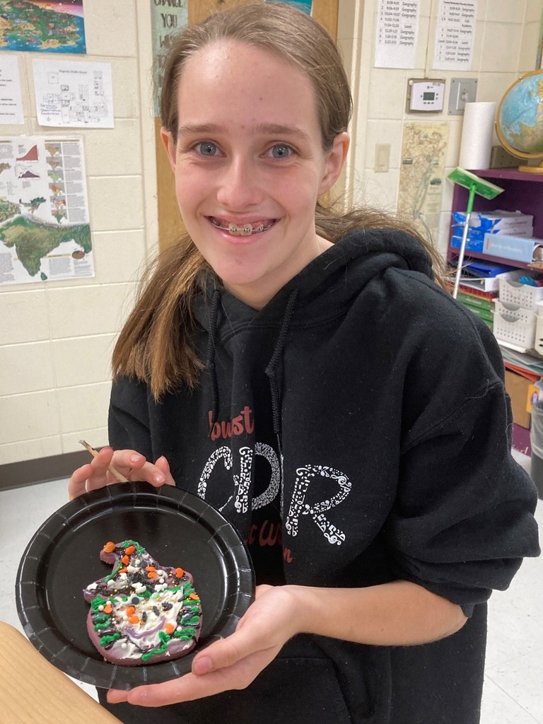 Elizabeth Brown holds up her witch cookie on a plate.