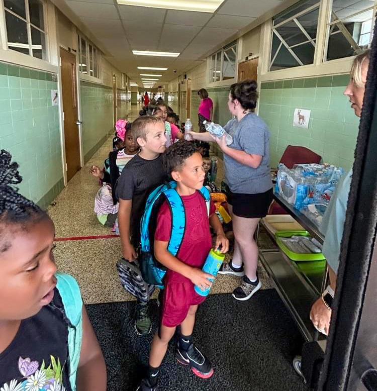 East Side Students receive water bottles before loading on the bus
