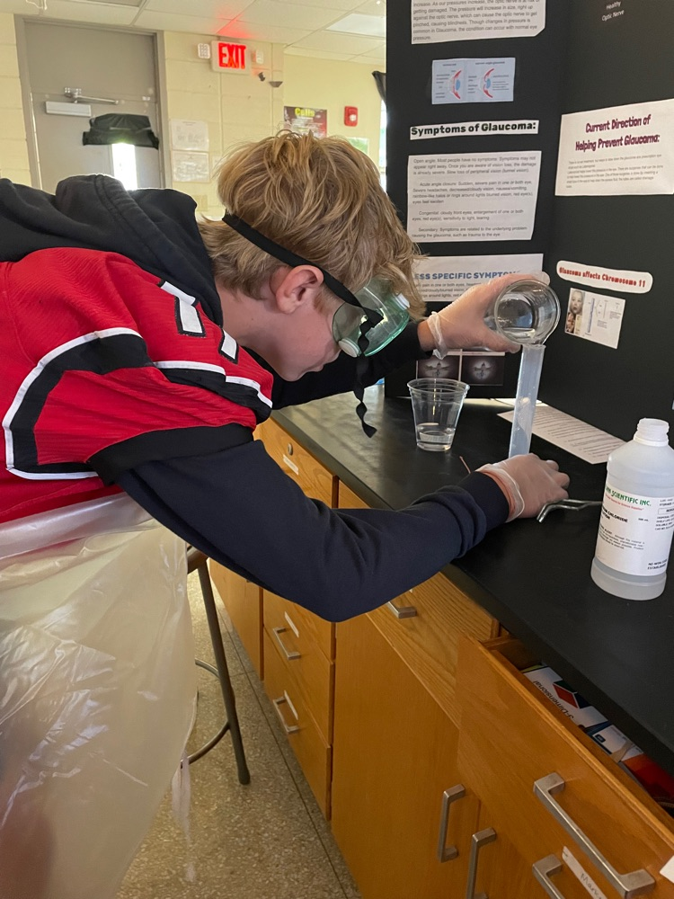 Ty Spurling pouring clear liquid from beaker to graduated cylinder