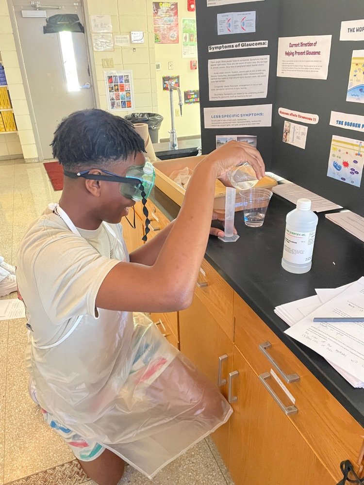 David Groguhe pouring clear liquid from beaker to graduated cylinder